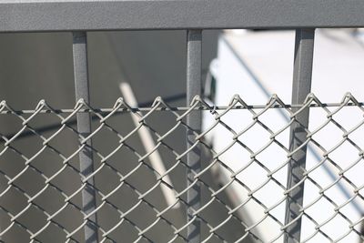 Close-up of chainlink fence against road