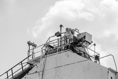 Low angle view of machinery at cement factory against sky