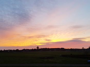 Scenic view of field against sky during sunset