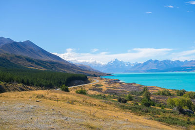 Scenic view of sea and mountains against blue sky