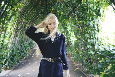 Young woman standing against plants at park