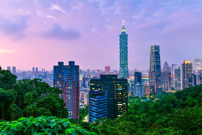 Modern buildings against cloudy sky during sunset