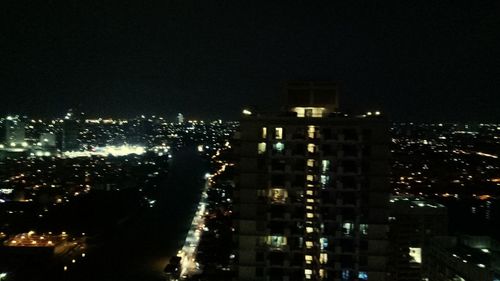 Illuminated cityscape against sky at night