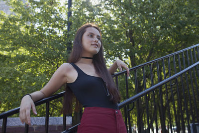 A young woman leaning against a railing