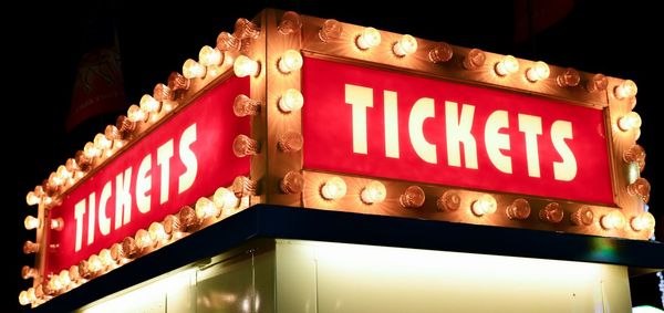 Low angle view of illuminated sign on building at night