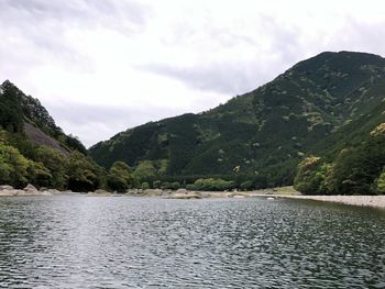 Scenic view of lake by mountains against sky