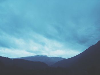 Scenic view of mountains against cloudy sky