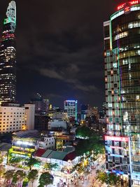 Illuminated buildings in city against sky at night