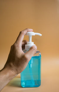 Close-up of hand holding bottle