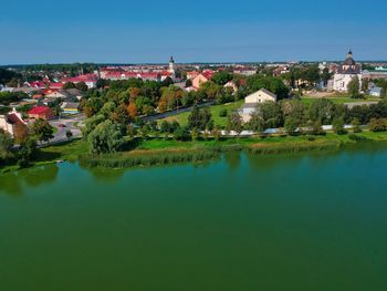 Scenic view of lake by buildings in town against sky