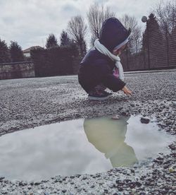 Rear view of boy playing in puddle