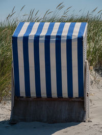 Close-up of sand on field against clear blue sky