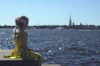 Woman standing on water against sky