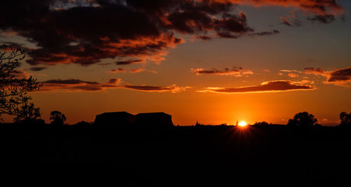 Scenic view of silhouette field against sky during sunset