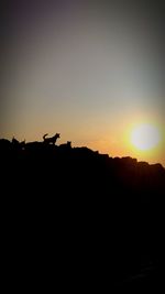 Silhouette landscape against sky during sunset