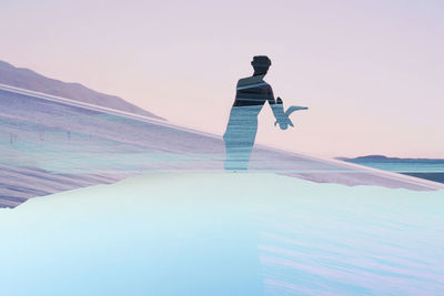 Man standing in sea against sky