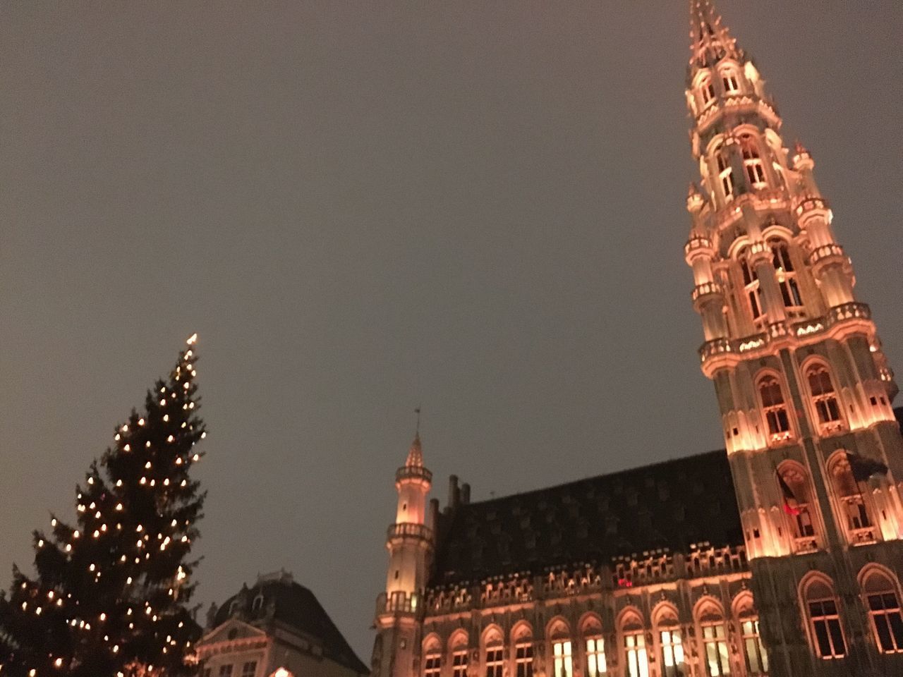 LOW ANGLE VIEW OF ILLUMINATED TOWER AT NIGHT