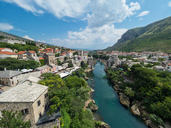 High angle view of river in city against cloudy sky