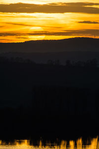 Silhouette landscape against sky during sunset