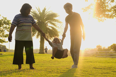 Rear view of people walking on field