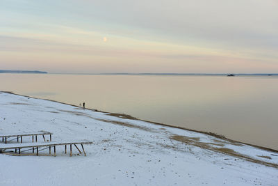 Scenic view of snow covered land against sky during sunset