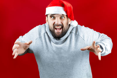 Portrait of mature man wearing hat against red background