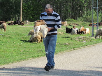 Full length of man with dog standing on road