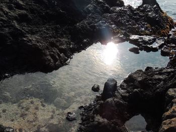 Rock formation in sea against sky