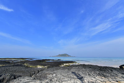 Scenic view of beach against blue sky