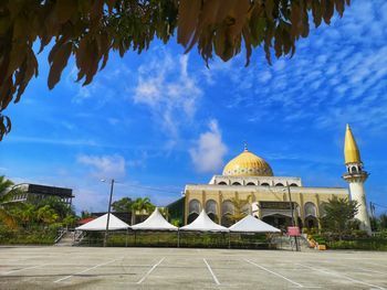 Church by building against blue sky