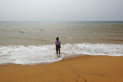 Rear view of woman looking at sea against sky