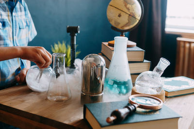 Hand holding glass bottles on table