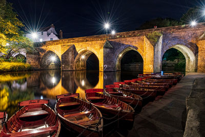 Arch bridge over river at night