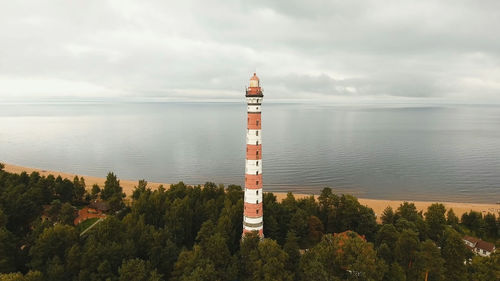 Lighthouse by sea against sky