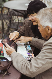 Elderly man and woman using gps navigation through digital tablet at table