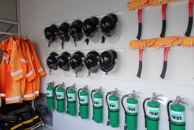 Fire extinguishers with helmets hanging on wall