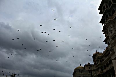 Low angle view of buildings against cloudy sky