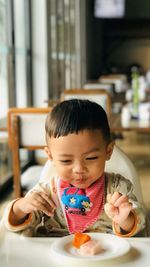 Portrait of boy eating food on table