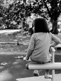 Rear view of girl on play equipment at park