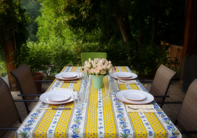 Empty chairs and table arranged at porch