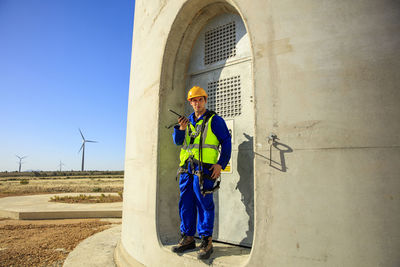 Technician holding walkie-talkie at wind turbine