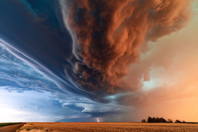 A supercell thunderstorm with dramatic clouds and lightning at sunset near st. francis, kansas.