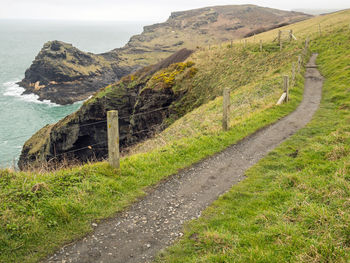 Scenic view of road by sea against mountain