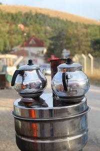 Close-up of kettles on container against mountain