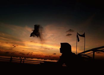 Silhouette man against orange sky during sunset