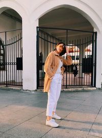 Portrait of woman standing against building entrance