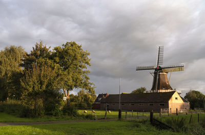Traditional windmill on field against sky