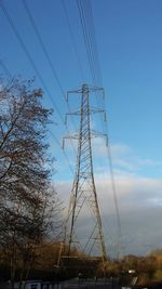 Low angle view of electricity pylon against blue sky