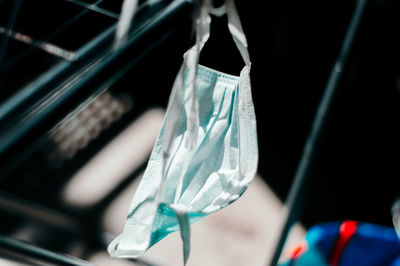 Close-up of disposable face mask drying on clothesline