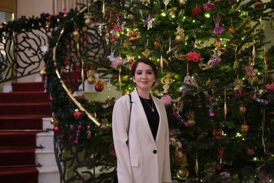 Portrait of young woman standing amidst plants on new year party
